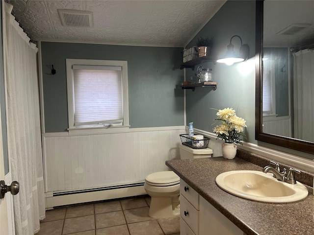 bathroom featuring a baseboard heating unit, a wainscoted wall, vanity, and visible vents