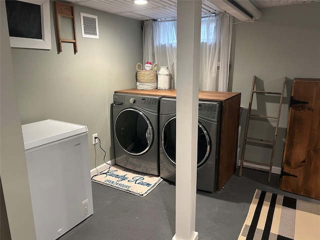 laundry area featuring washer and dryer, visible vents, baseboards, and laundry area