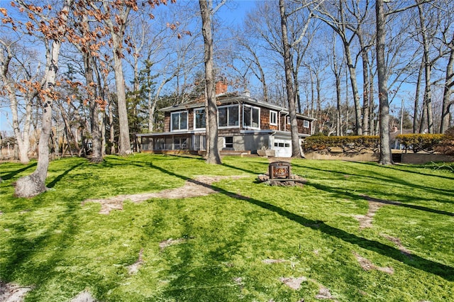 780 Beebe Dr, Cutchogue, NY 11935 - rear view of house with a lawn, an attached garage, a chimney, and a sunroom
