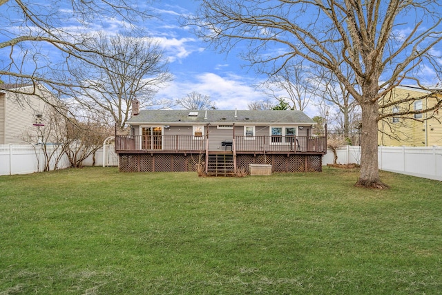 back of house with a lawn, a wooden deck, and a fenced backyard