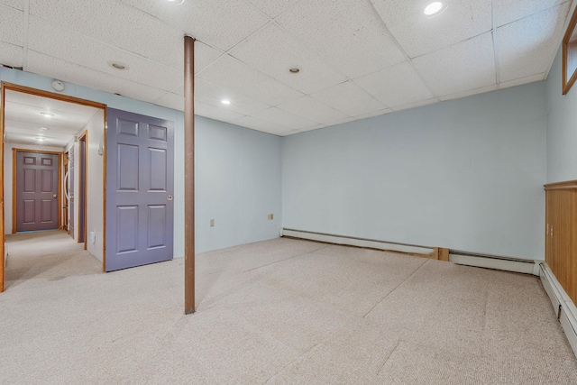 finished below grade area featuring a baseboard heating unit, recessed lighting, carpet, and a drop ceiling