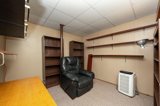 sitting room featuring a drop ceiling and light colored carpet