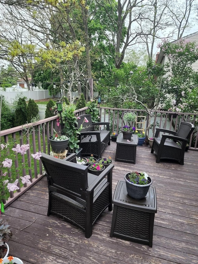 deck featuring an outdoor living space and fence