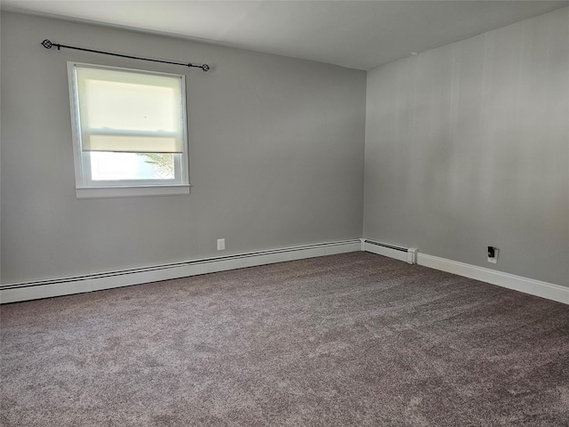 spare room featuring dark carpet and a baseboard radiator