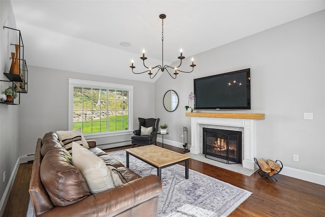 living area with a notable chandelier, baseboard heating, baseboards, wood finished floors, and a baseboard radiator