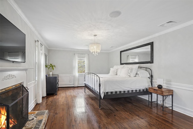 bedroom featuring a lit fireplace, visible vents, crown molding, dark wood-style floors, and a notable chandelier