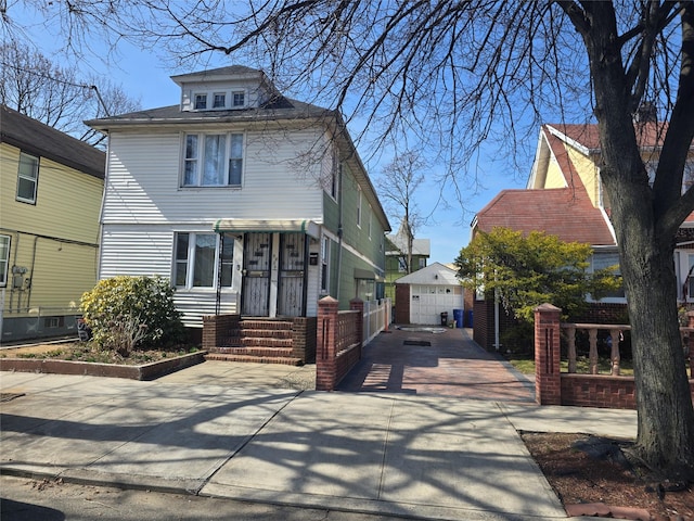 american foursquare style home with an outbuilding, concrete driveway, and a shingled roof