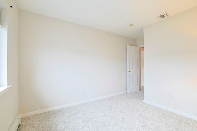 carpeted empty room featuring baseboards, visible vents, and baseboard heating