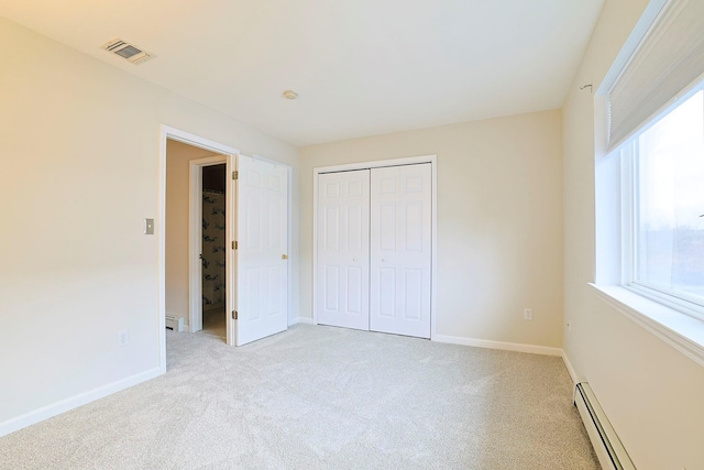 unfurnished bedroom with visible vents, light colored carpet, baseboards, and baseboard heating