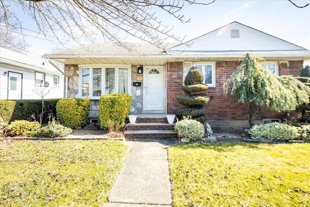 view of front facade with brick siding and a front lawn