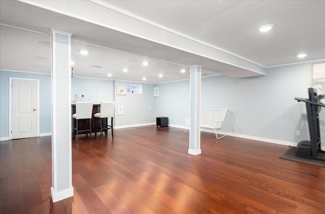 finished basement with recessed lighting, bar area, baseboards, and wood finished floors