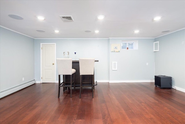 interior space featuring visible vents, crown molding, baseboards, dark wood finished floors, and a breakfast bar area