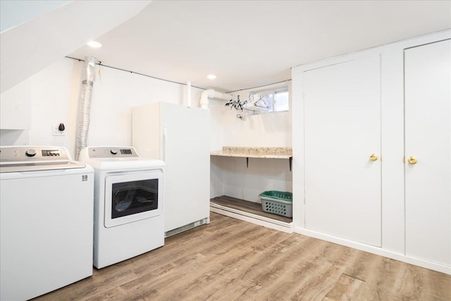 washroom featuring light wood-style flooring, laundry area, and washer and clothes dryer