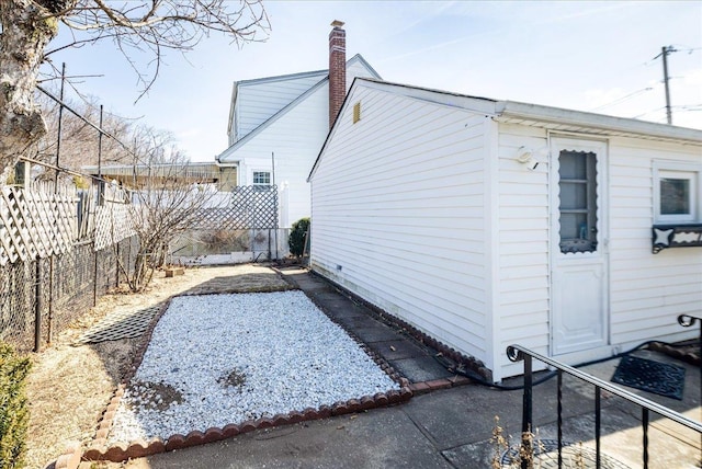 view of property exterior with fence and a chimney