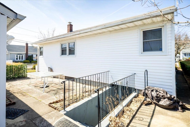 back of property featuring a patio and a chimney