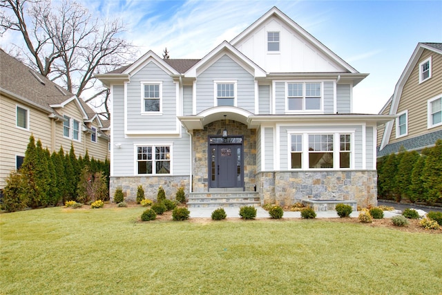 view of front facade with board and batten siding, a front yard, and stone siding