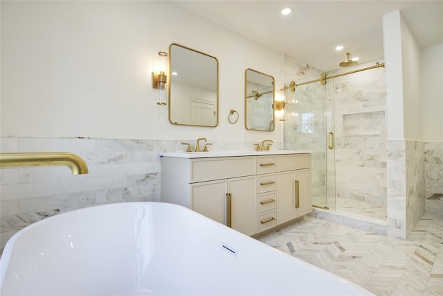 bathroom with a marble finish shower, a soaking tub, a sink, and double vanity