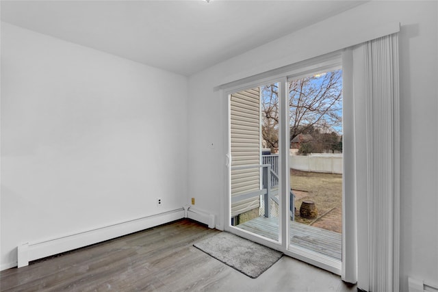 doorway to outside featuring a baseboard heating unit and wood finished floors