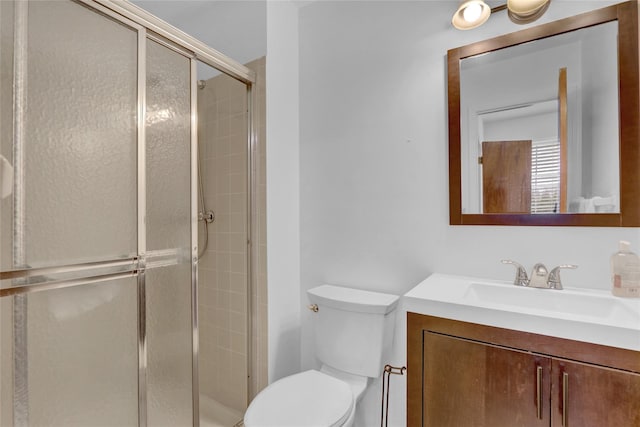 bathroom featuring vanity, toilet, and a shower stall