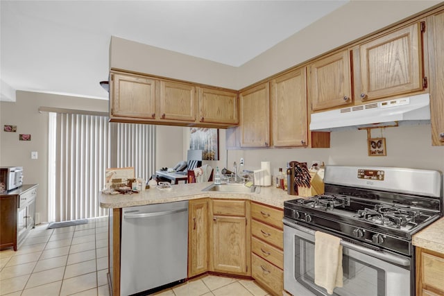 kitchen featuring a peninsula, a sink, stainless steel appliances, light countertops, and under cabinet range hood