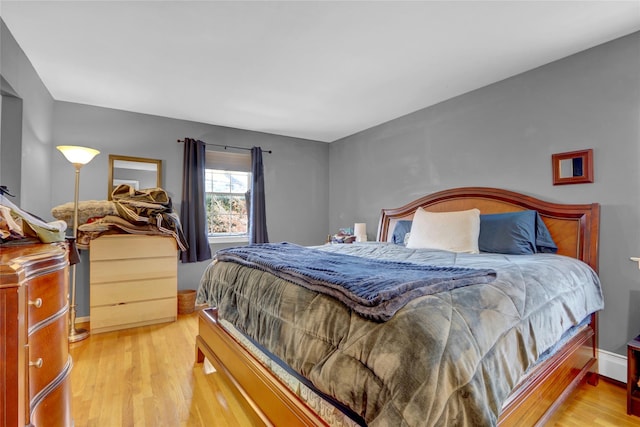 bedroom with baseboards and light wood finished floors