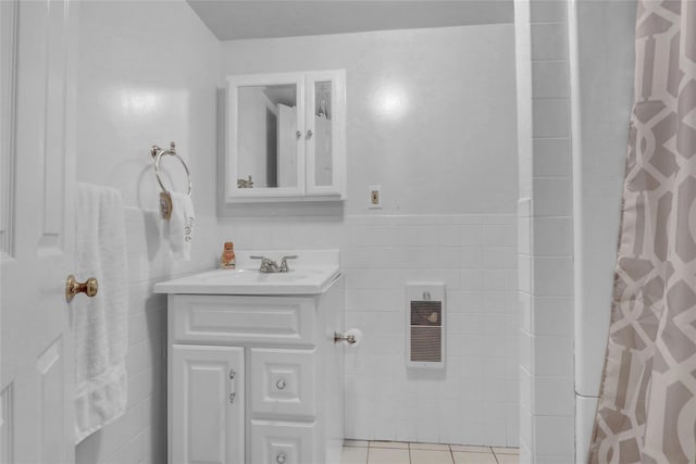 bathroom featuring visible vents, vanity, a shower with curtain, tile patterned floors, and tile walls