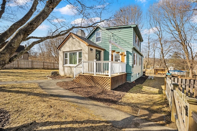 exterior space featuring a deck, a chimney, and fence