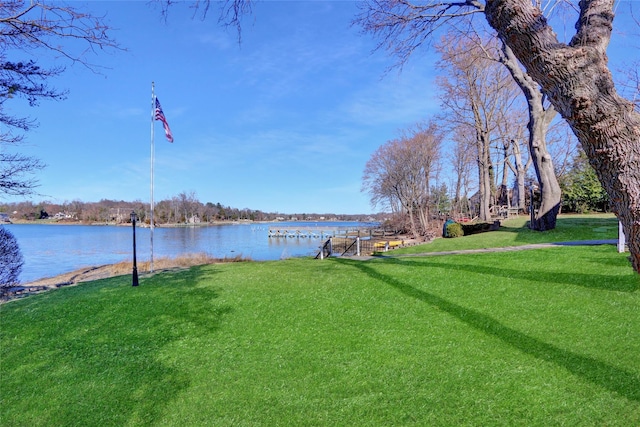 exterior space featuring a lawn and a water view