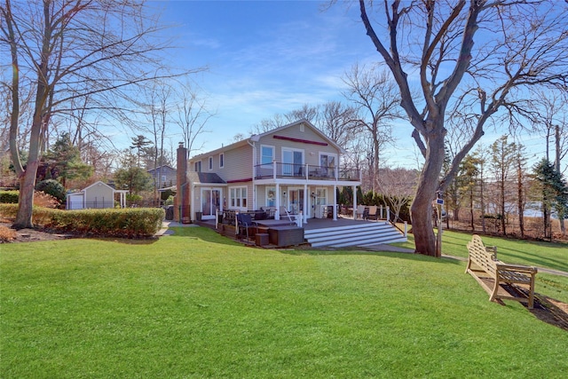 back of house with a wooden deck, a balcony, a yard, and a chimney