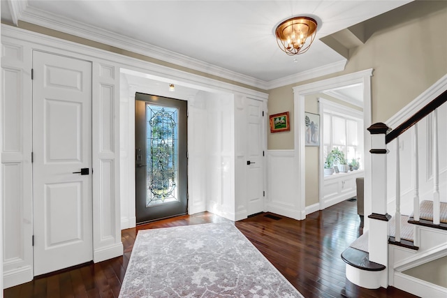 foyer with a notable chandelier, dark wood-style floors, stairs, and crown molding