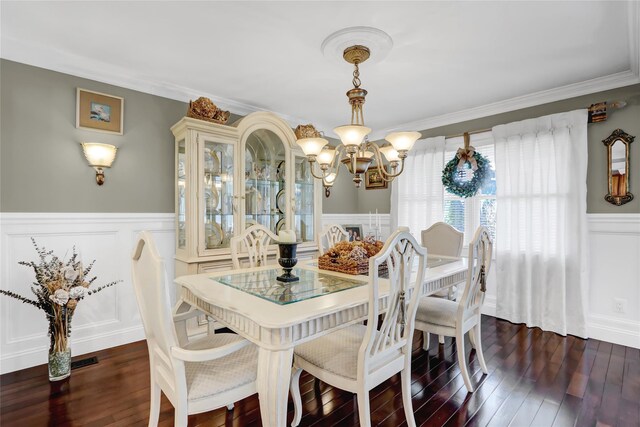 dining area featuring a wainscoted wall, a chandelier, dark wood-style flooring, and a decorative wall