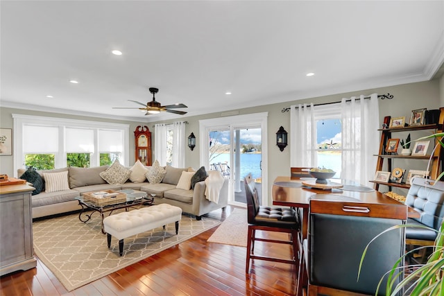 living room featuring hardwood / wood-style flooring, ornamental molding, a healthy amount of sunlight, and ceiling fan