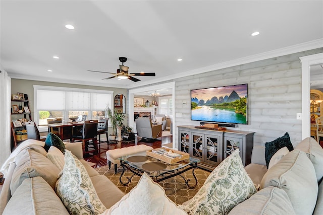 living room with recessed lighting, wood finished floors, crown molding, and ceiling fan with notable chandelier