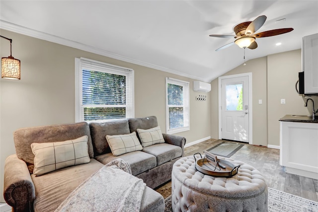 living room featuring a wall mounted air conditioner, crown molding, light wood finished floors, baseboards, and ceiling fan