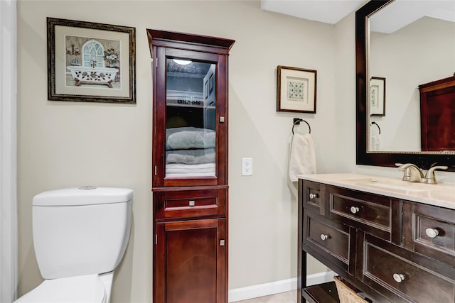 half bath with vanity, toilet, and baseboards