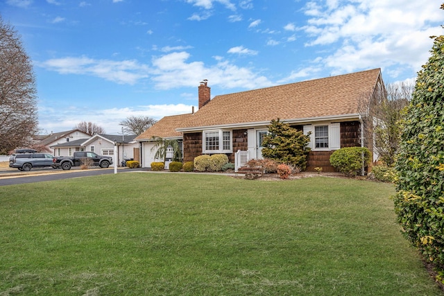 view of front of house featuring aphalt driveway, an attached garage, a chimney, and a front yard