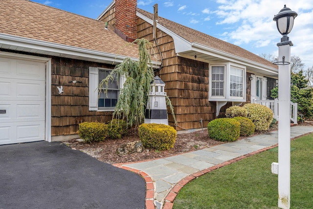 view of property exterior with a chimney and a shingled roof