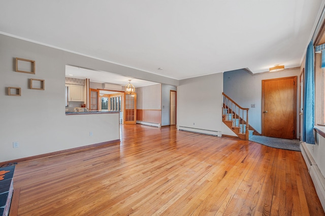 unfurnished living room featuring baseboard heating, stairway, a baseboard heating unit, and light wood-style floors