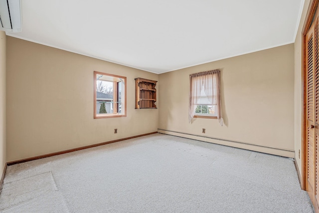 spare room featuring a healthy amount of sunlight, baseboards, baseboard heating, and carpet floors