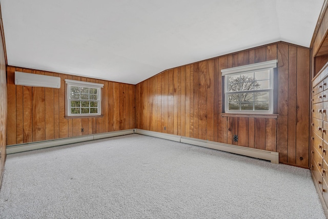 empty room featuring wooden walls, a wall mounted AC, lofted ceiling, and carpet floors