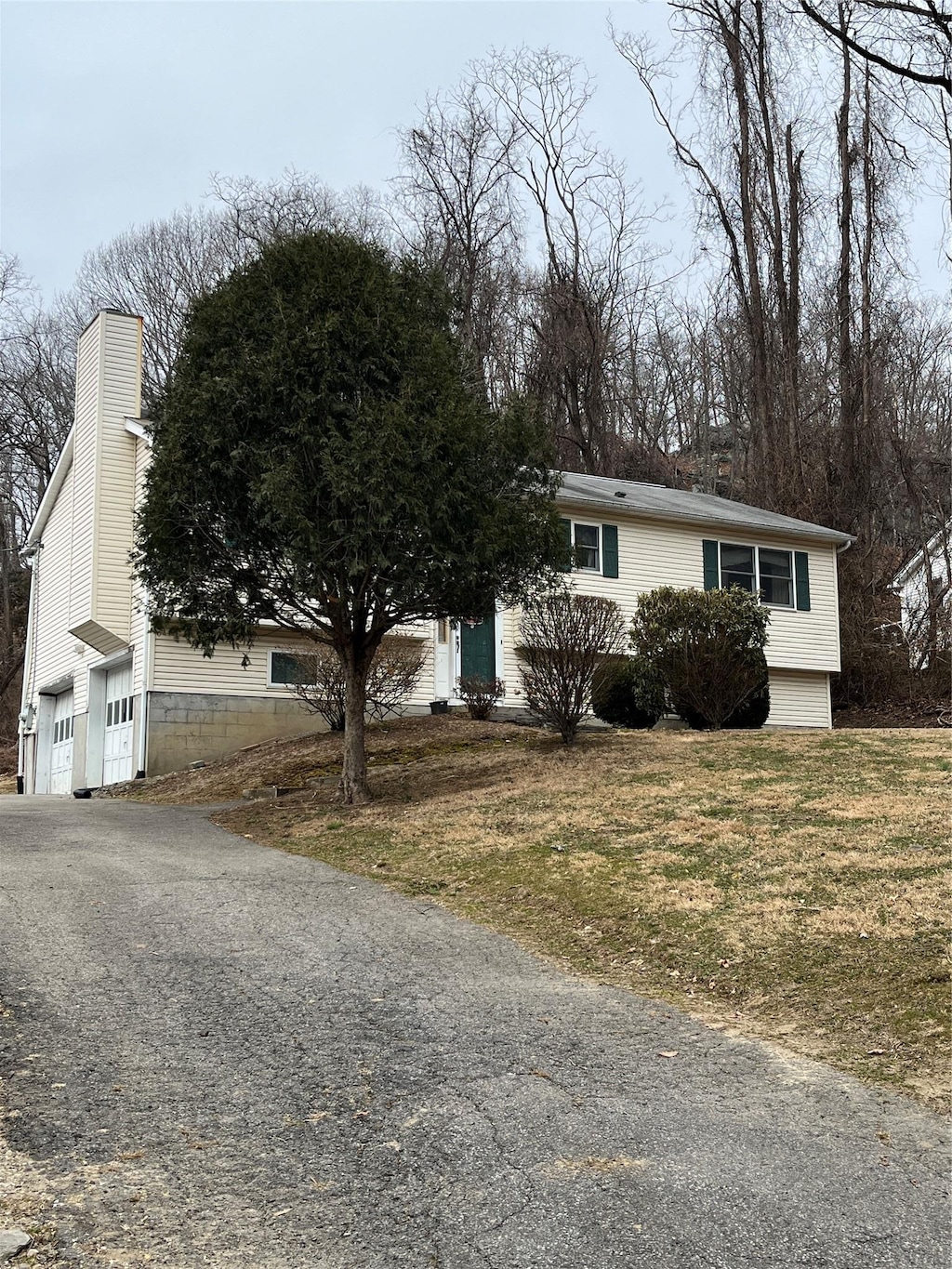 view of front facade featuring a garage, a front lawn, and driveway