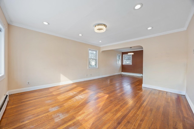 unfurnished room with hardwood / wood-style floors, a baseboard radiator, arched walkways, and ornamental molding