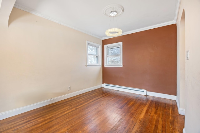 unfurnished room featuring a baseboard heating unit, crown molding, baseboards, and wood-type flooring