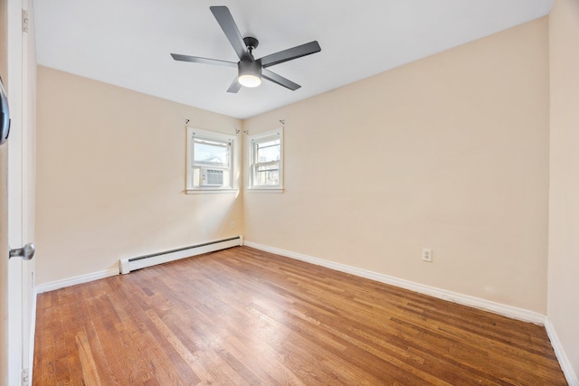 spare room with a baseboard heating unit, light wood-style floors, baseboards, and ceiling fan