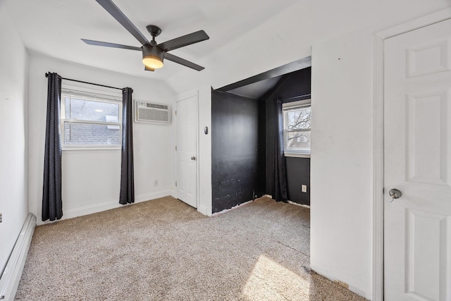 unfurnished bedroom with carpet, a wall unit AC, vaulted ceiling, baseboard heating, and a ceiling fan