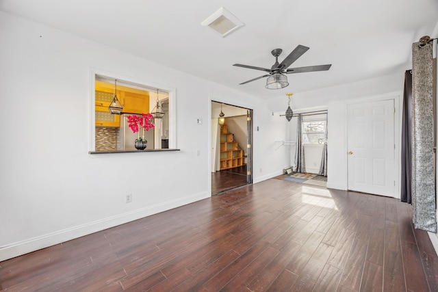 spare room featuring visible vents, baseboards, ceiling fan, stairs, and wood finished floors