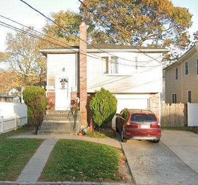 view of front of house featuring fence and driveway