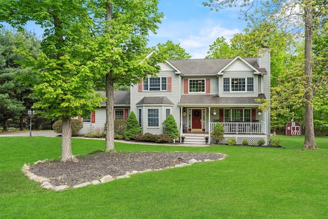 33 Sutherland Dr, Highland Mills, NY 10930 - view of front of property with covered porch, a shed, a chimney, an outdoor structure, and a front lawn