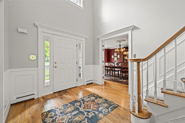 33 Sutherland Dr, Highland Mills, NY 10930 - entrance foyer with baseboard heating, a chandelier, a wainscoted wall, wood-type flooring, and a towering ceiling