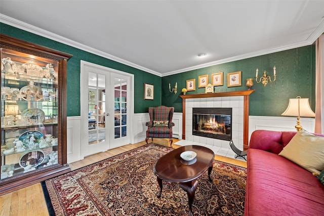 33 Sutherland Dr, Highland Mills, NY 10930 - living area with french doors, wood finished floors, crown molding, a tiled fireplace, and wainscoting